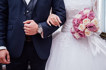 Wedding couple holding hands with pink rose bouquet