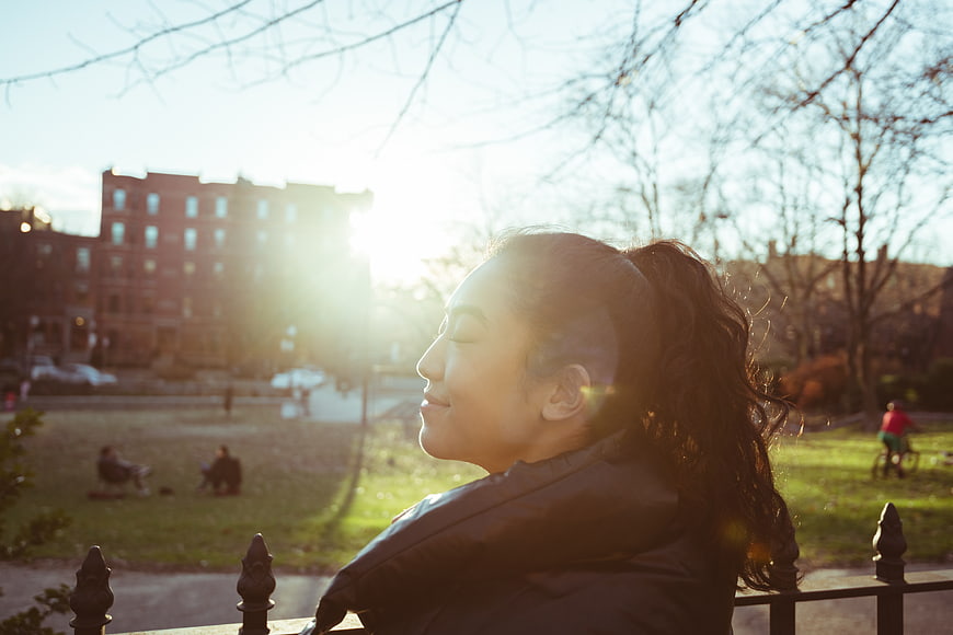 Young Asian Woman Smiling in Park Sunlight