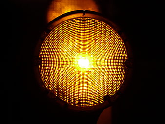 Close-up of glowing yellow warning light with grid pattern