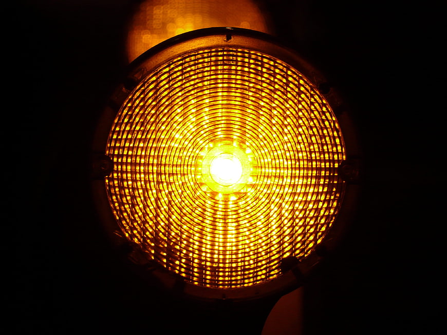 Close-up of glowing yellow warning light with grid pattern