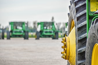 Close-up of Green Tractor Tire with Fleet in Background