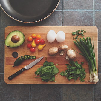 Fresh healthy breakfast ingredients on wooden cutting board