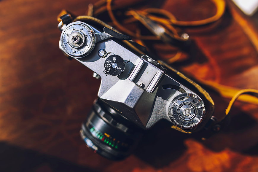 Vintage silver rangefinder camera on wooden table