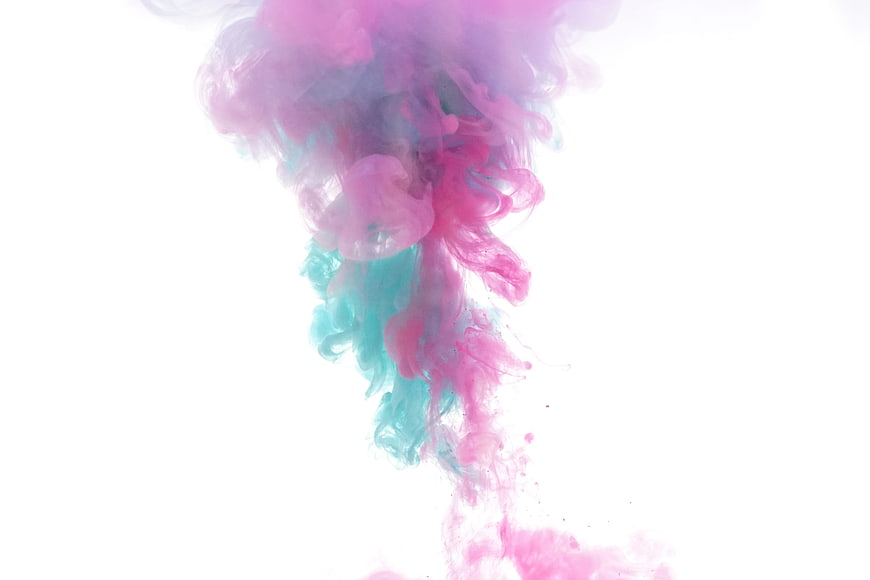 Abstract pink and blue ink swirling in water on white background