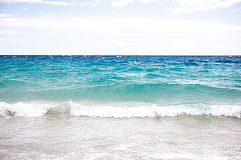 Turquoise Ocean Waves Crashing on Sandy Beach Shore