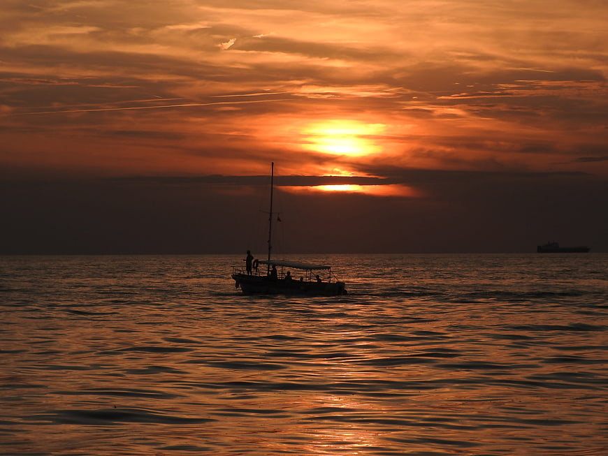 Silhouette of boat on ocean during golden sunset