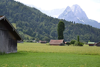 Rustic Bavarian Alps Landscape with Wooden Barns and Mountains