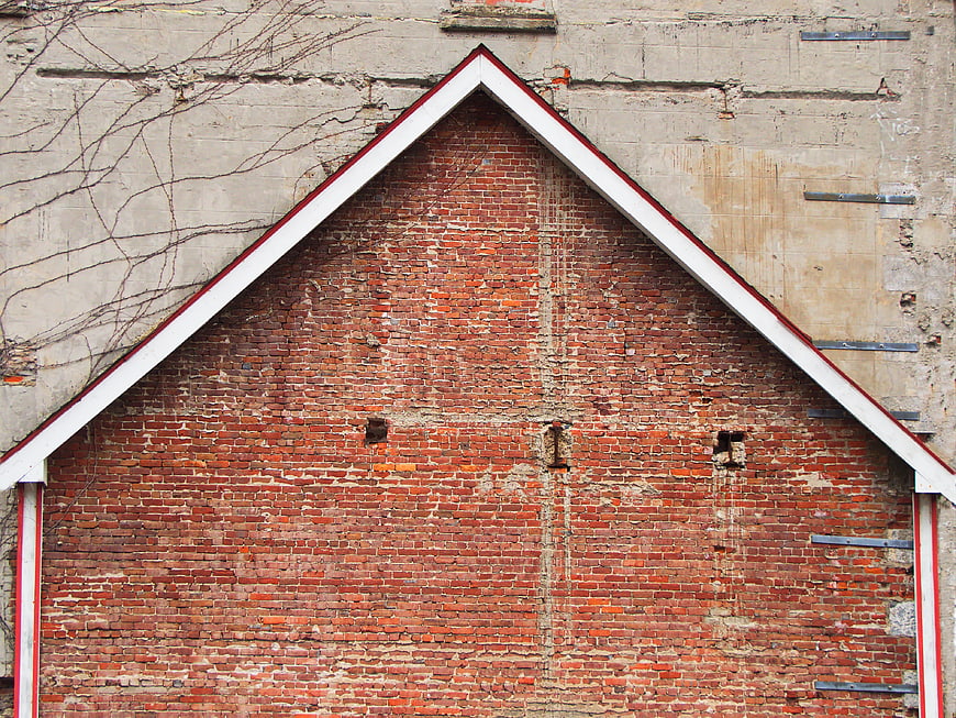 Weathered red brick gable wall with white trim