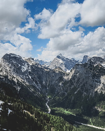 Majestic Alpine Mountain Range with Snowy Peaks and Forested Valley