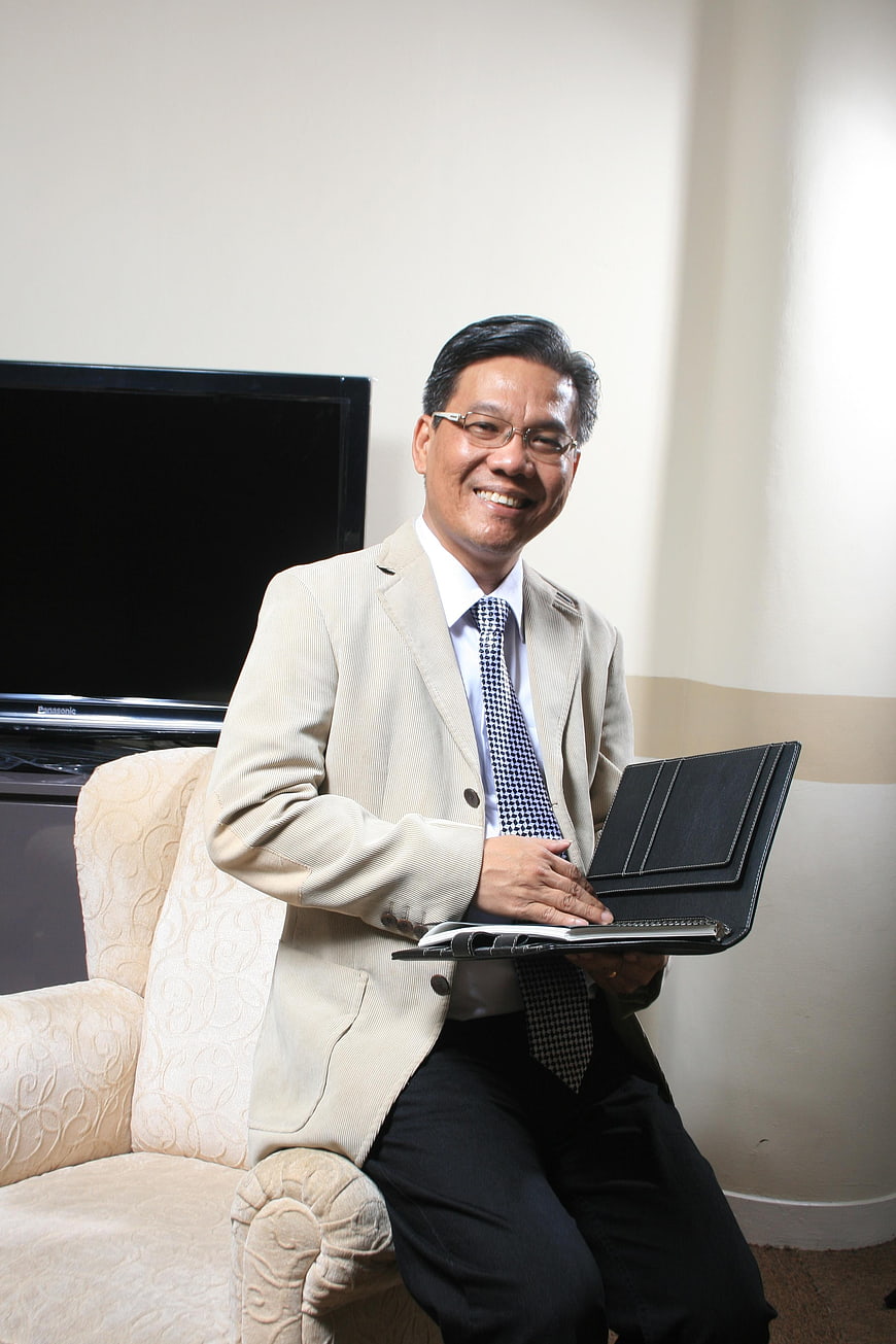 Smiling Asian businessman holding portfolio in office
