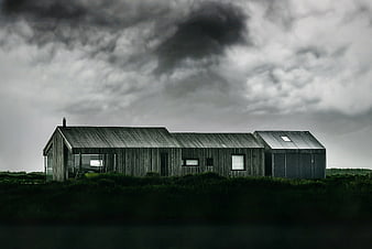 Modern wooden house under dramatic stormy sky