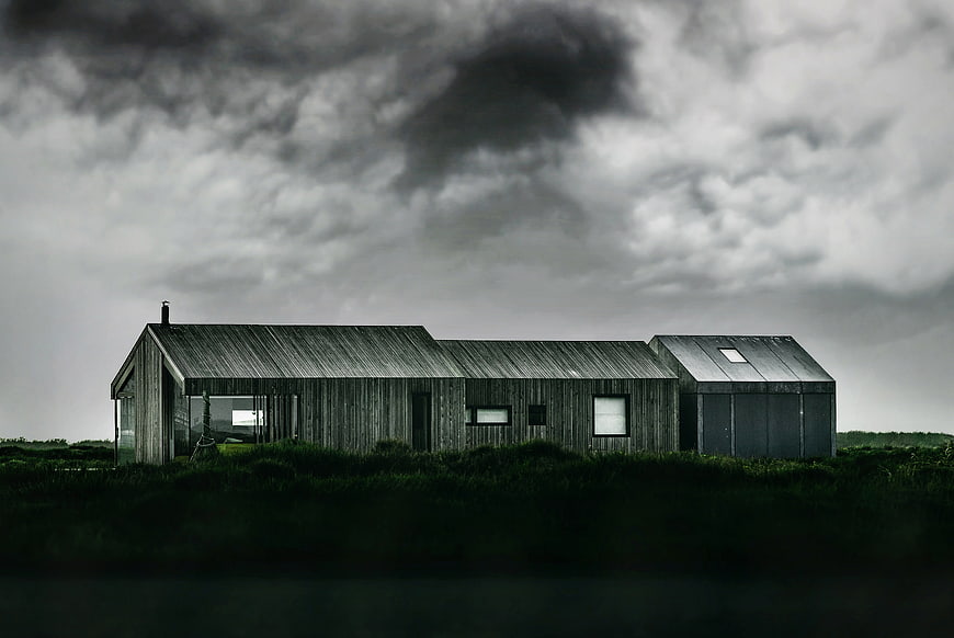 Modern wooden house under dramatic stormy sky