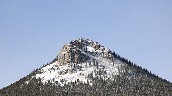 Snow-Capped Rocky Mountain Peak Against Clear Blue Sky