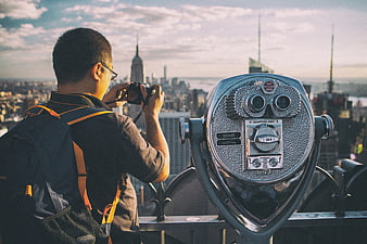 Tourist photographing New York City skyline from observation deck