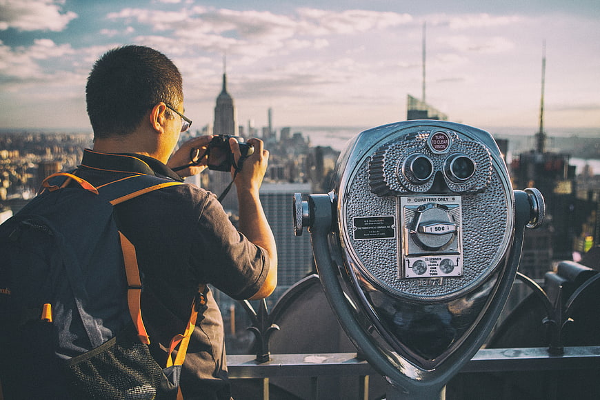 Tourist photographing New York City skyline from observation deck