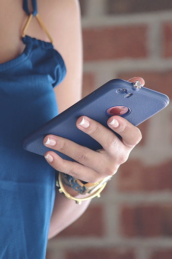 Woman holding blue smartphone with French manicure