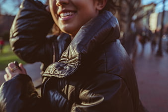 Close-up of smiling woman in leather jacket outdoors