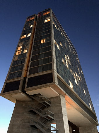 Low angle view of modern brutalist skyscraper at dusk