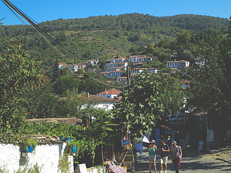 Tourists walking in Sirince village, Turkey with hillside houses