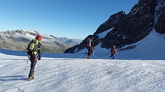 Alpine climbers roped together on a snowy mountain glacier