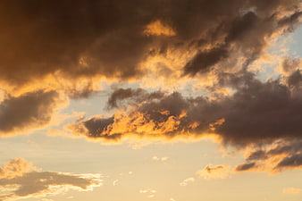 Dramatic sunset clouds with golden light and dark shadows