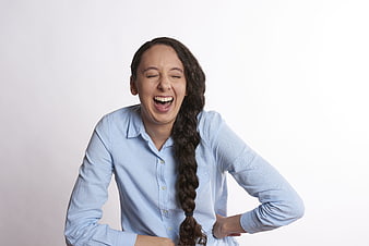 Young woman laughing with hand on back against white background