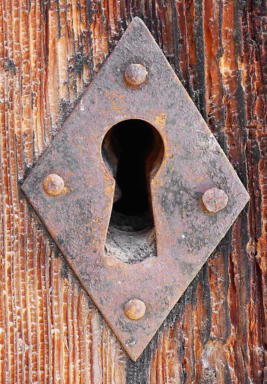 Rusty Iron Keyhole on Weathered Wooden Door