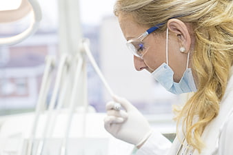 Female Dentist Examining Patient with Dental Tools