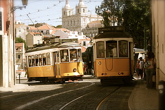 Vintage Yellow Trams on Cobblestone Street in Lisbon