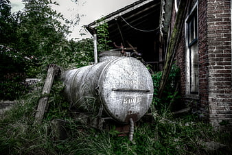 Rusty Metal Tank in Overgrown Abandoned Yard