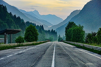 Empty Mountain Road at Dusk with Misty Forest Background