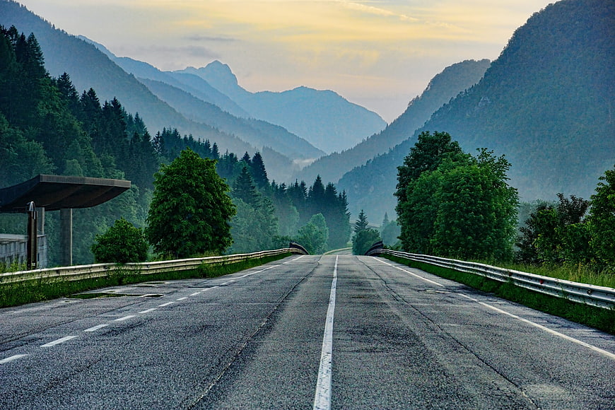 Empty Mountain Road at Dusk with Misty Forest Background