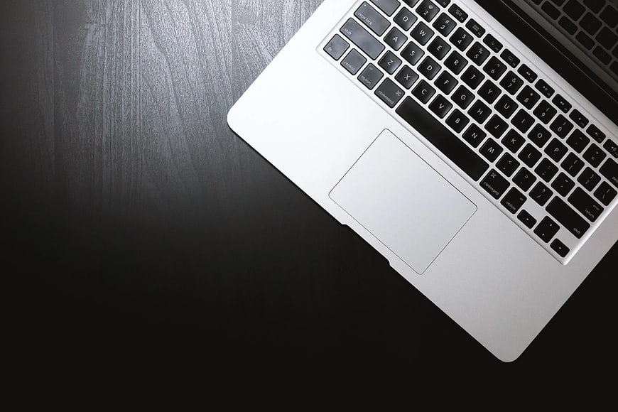 Silver Laptop Keyboard on Dark Wood Desk
