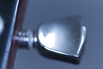Close-up of Chrome Guitar Tuner Peg on Blue Background
