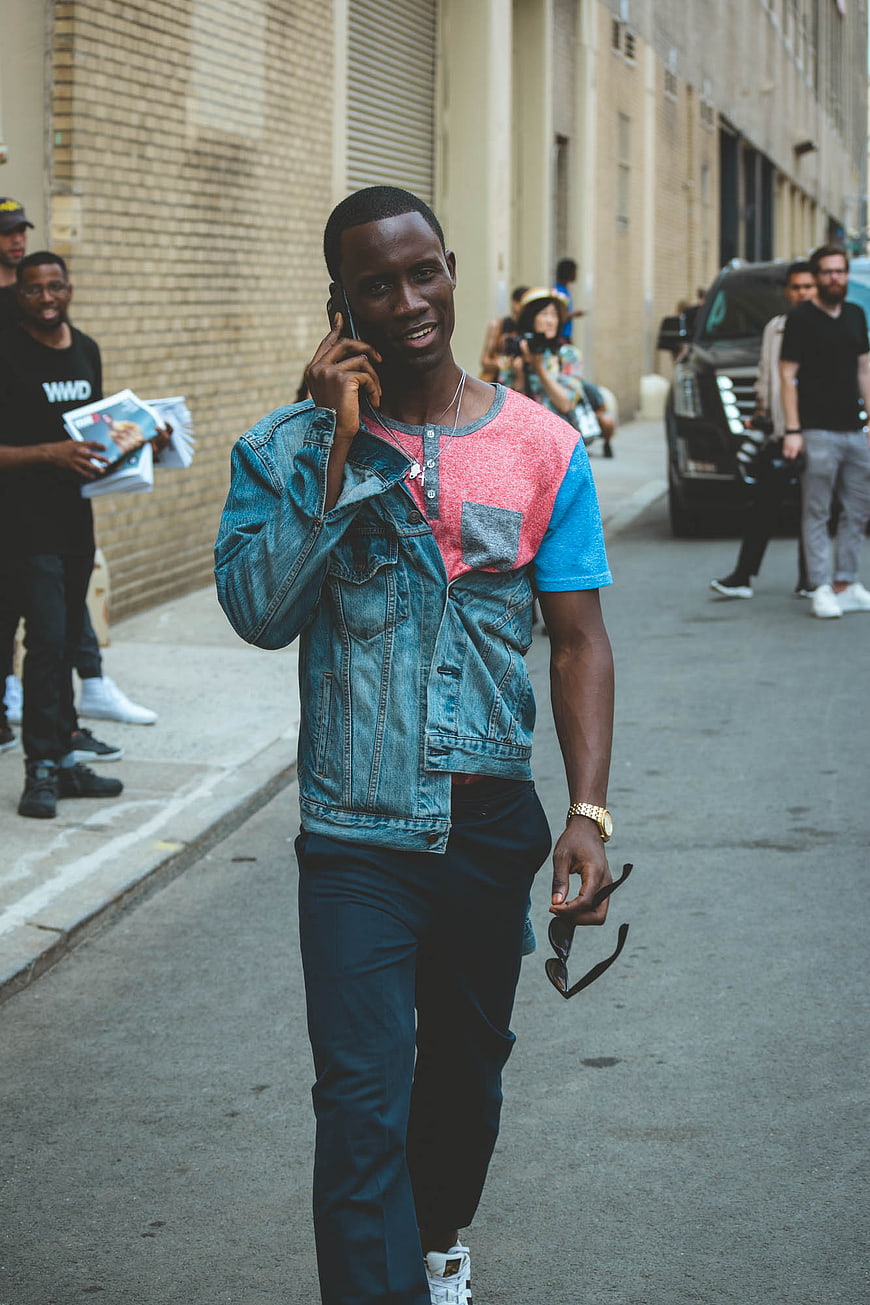Stylish Black Man Walking and Talking on Smartphone in City Street