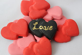 Heart-shaped chocolates with gold love text on white background