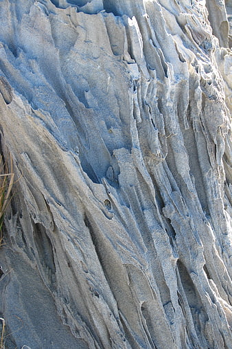 Closeup of blue-gray eroded rock texture with vertical striations