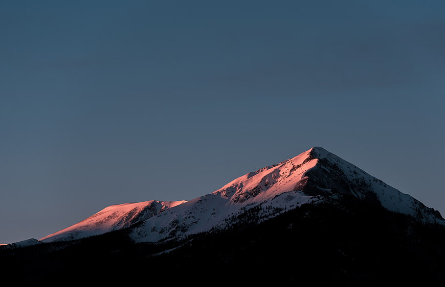 Snowy Mountain Peak with Pink Alpenglow at Dusk