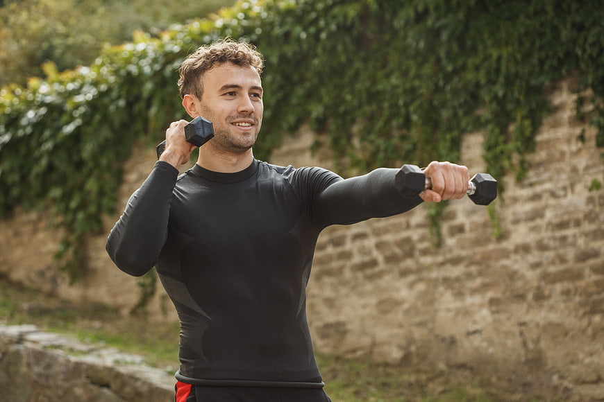 Man doing outdoor dumbbell workout exercise