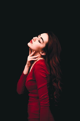 Woman in Red Dress with Eyes Closed on Black Background