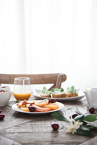 Healthy breakfast spread with fruit, juice, and toast on rustic table