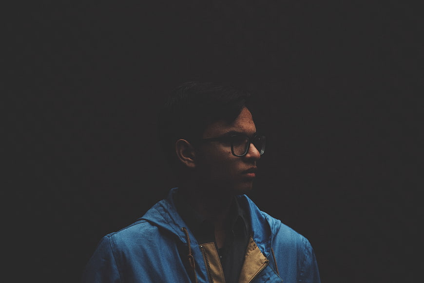 Moody Portrait of Man in Blue Jacket and Glasses