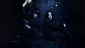Gothic Couple Sitting Back to Back in Dark Starry Room