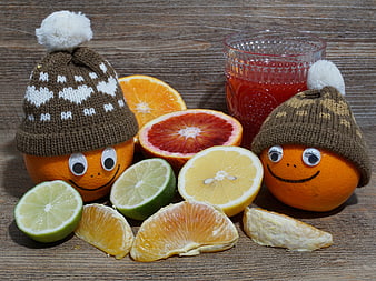 Cute Citrus Fruits With Knitted Hats And Juice On Wooden Table
