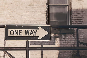 Vintage One Way Street Sign on White Brick Wall