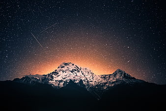 Snowy Mountain Peak Under Starry Night Sky with Shooting Stars