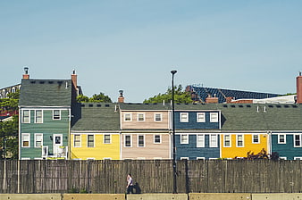 Colorful row houses behind wooden fence with pedestrian