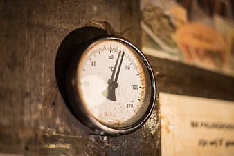 Close-up of vintage industrial thermometer on metal surface