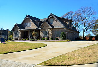 Modern suburban house with stone facade and wide driveway