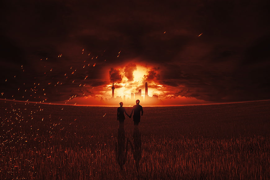 Silhouette of couple walking away from burning city skyline